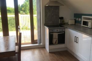 a kitchen with a stove top oven next to a window at Lakeside Loft in Hereford