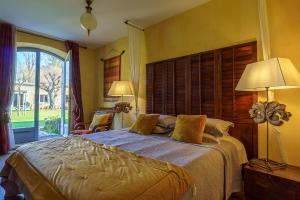 um quarto com uma cama grande e uma janela grande em Chambres d'hôtes Domaine de Ginouilhac em Le Taillan-Médoc