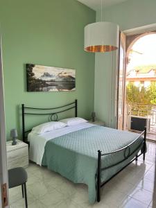 a bedroom with a bed and a large window at Casa vacanze al castello in Zafferana Etnea