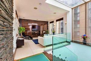 uma sala de estar com piso em vidro e uma televisão em Finest Retreats - King Charles House em Londres