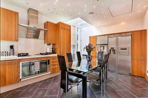 a kitchen with a dining room table and chairs at Finest Retreats - King Charles House in London