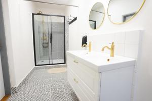 a white bathroom with a sink and a shower at White Wolf House Hostel & Apartments in Prague