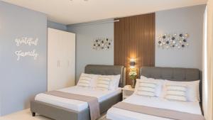 duas camas num quarto de hotel com almofadas brancas em Palawan Twin-Bed Paradise with a Balcony plus FREE Pool, Gym & Parking-7Kunzite em Puerto Princesa
