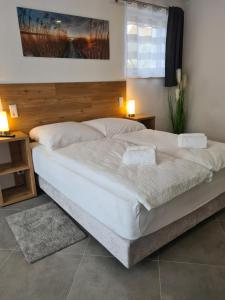 a large white bed in a bedroom with two lamps at WellandHome Aalen - 6 Rooms in Aalen