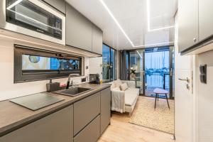 a kitchen with a sink and a living room at The Homeboat Company Parque das Nações-Lisboa in Lisbon