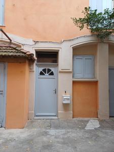 an orange building with a white door and two windows at Studio Perpignan in Perpignan