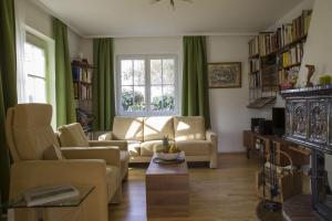 uma sala de estar com um sofá e cadeiras e uma janela em Dreimädelshaus em Uhldingen-Mühlhofen
