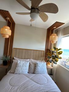 a bedroom with a bed with a ceiling fan at Condotel DC MARINA SPATIAL FELINVEST in Dumaguete