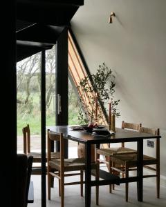 a dining room with a table and chairs and a window at Wilder Retreats - A Frame Cabins in Haverfordwest