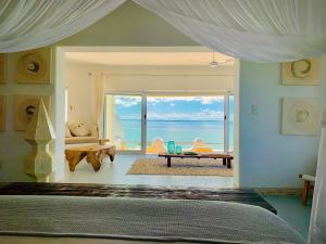 una camera da letto con un letto con vista sull'oceano di Villa Santorini a Vilanculos