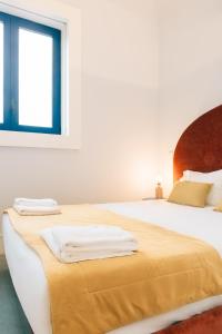 - une chambre blanche avec un lit et des serviettes dans l'établissement ORM Padrão Apartment, à Porto