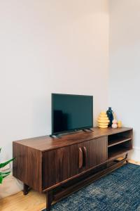 - un salon avec une télévision sur un centre de divertissement en bois dans l'établissement ORM Padrão Apartment, à Porto