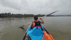 Un uomo è in un kayak sull'acqua di Maitinga SESC Bertioga a Bertioga