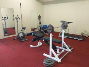 un gimnasio con varios equipos de ejercicio sobre una alfombra roja en Modern Comfy 2-Bedroom Self-catering Apartment - 1 minute walk to Strand beach en Strand