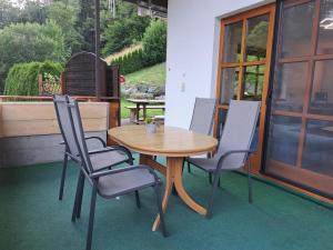 a wooden table and chairs on a patio at Ferienwohnung Irene in Galgenul