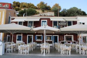 a group of tables and umbrellas in front of a building at PARALIA Stoudios in Parga