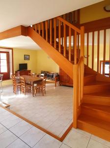 a living room with a wooden staircase and a table at L'AUBERGE DE LA PORTE in Saint-Jouan-des-Guérets