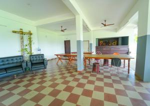 a living room with a table and chairs and a checkered floor at Prime Casadel Rooms And Apartments in Kakkanad