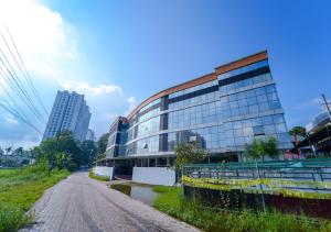 a building on the side of a dirt road at Prime Casadel Rooms And Apartments in Kakkanad