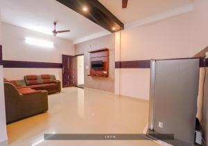 a living room with a couch and a tv at Prime Casadel Rooms And Apartments in Kakkanad