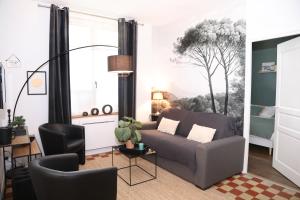 ein Wohnzimmer mit einem Sofa und einem Tisch in der Unterkunft Suite Garden by La Boîte En Plus in Senlis