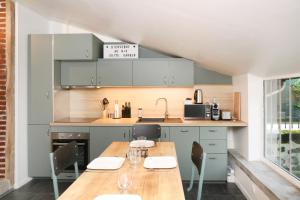 eine Küche mit einem Holztisch und Stühlen in der Unterkunft Suite Garden by La Boîte En Plus in Senlis