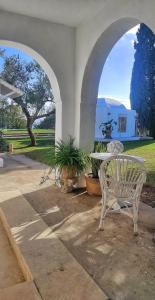 a white bench sitting in a patio with an archway at Lella Zohra, Studio avec Piscine à Sidi Bou Said in Sidi Bou Saïd