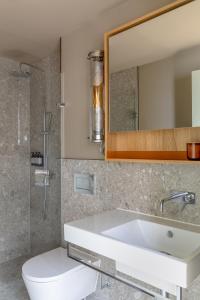 a bathroom with a sink and a toilet and a mirror at Locke at Broken Wharf in London