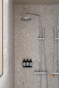 a shower with three bottles on a wall at Locke at Broken Wharf in London
