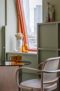 einen Tisch und einen Stuhl in einem Zimmer mit Fenster in der Unterkunft Locke at Broken Wharf in London