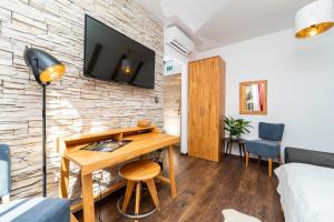 a room with a desk and a tv on a brick wall at B&B Villa Sumrak Plitvica Rooms in Plitvička Jezera