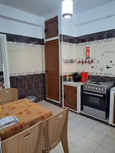 a kitchen with a table and a stove top oven at Residence Rahma 