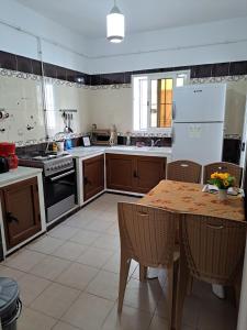 a kitchen with a wooden table and a kitchen with a stove at Residence Rahma 
