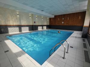 a person swimming in a large indoor swimming pool at Le Crey du Quart in Valmeinier
