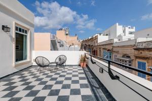 a balcony with two chairs and a checkered floor at PIJU LUX APARTMENTS in Sliema