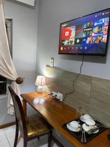 uma mesa de madeira com uma televisão na parede em Comrades Oasis Guest House em Pietermaritzburg
