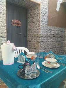 une table bleue avec un chiffon de table bleu sur une table dans l'établissement Grotte de pêcheurs RITAJ, Aglou, à Tiznit
