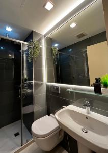 a bathroom with a toilet and a sink at Prime Posh Downtown Condo in Manila