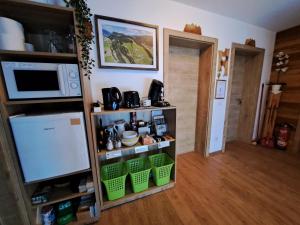 a kitchen with a shelf with baskets and a microwave at Sauschneidhof - Radstadt in Radstadt