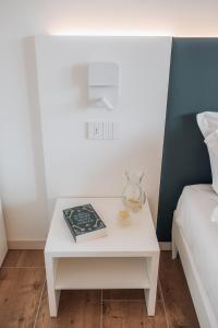 a white table with a book on it next to a bed at Sea Breeze in Caorle
