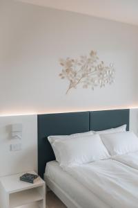 a white bed with a blue headboard and white pillows at Sea Breeze in Caorle