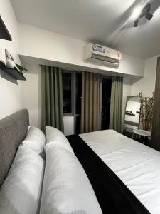 a bedroom with a bed and a air conditioner at Prime Posh Downtown Condo in Manila