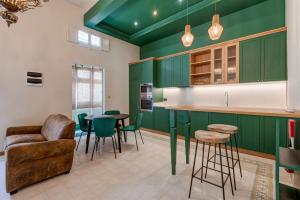 a kitchen with green cabinets and a table and chairs at PIJU LUX APARTMENTS in Sliema
