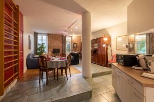 a kitchen and living room with a table and chairs at Gite du Corupsis in Villeneuve-sur-Lot