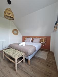 a bedroom with a large bed and a stool at Chez Iris in Jebsheim