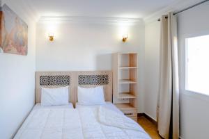 1 dormitorio con cama blanca y ventana en PLAYA HOTEL en Dakhla