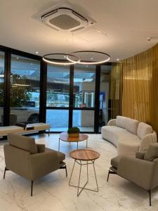 a living room with couches and tables and windows at Hotel Aeroporto de Congonhas - Flat in Sao Paulo