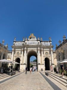 an arch in a building with people walking through it at Le Cocon : à deux pas de la gare in Nancy