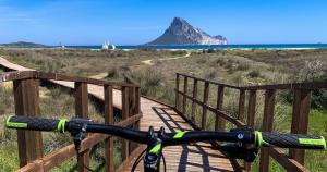 a bike on a bridge with a mountain in the background at Residence Hotel Lu Nibareddu in San Teodoro