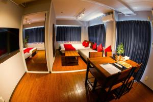 - un salon avec un canapé et une table dans l'établissement e-stay namba, à Osaka